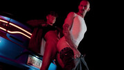 Bald man with tattoos is banged next to the vehicle
