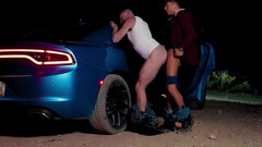 Bald man with tattoos is banged next to the vehicle