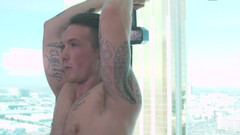 Tattooed man works out with weights and a submissive fella