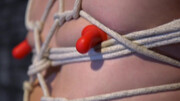Clothed male plays with obedient man's cock during a sexy bondage treat