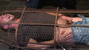 Muscular man is tied up and caged by a sadistic pervert