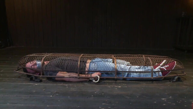 Muscular man is tied up and caged by a sadistic pervert