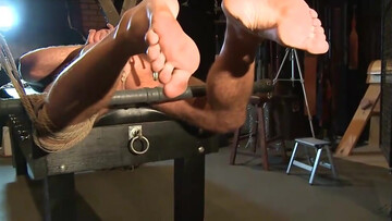 Tied up man is in the room and the sadistic dom tests him