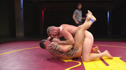 Muscular men make out in the ring in a rough wrestling play