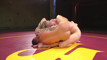 Muscular men make out in the ring in a rough wrestling play