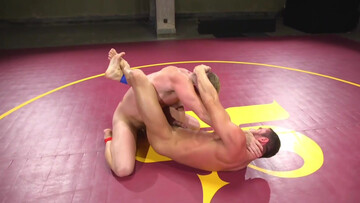Muscular men make out in the ring in a rough wrestling play